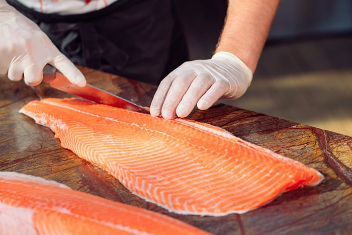 chef-cuts-salmon-table